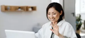 a woman who has a video call smiling and waving