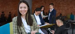 an Asian woman smiling while thinking about why Hong Kong Professionals Are Moving to the USA