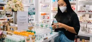 an Asian woman looking at a bottle