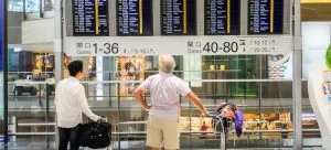 two asians looking at a digital screen and thinking about Which Canadian Provinces Attracts Hong Kongers the Most
