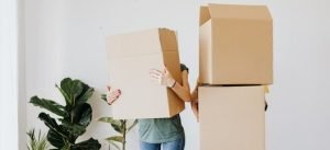 a couple holding boxes and trying to stay injury-free when heavy lifting on moving day