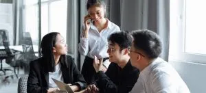 a group of asians in an office talking about Which Canadian Provinces Attracts Hong Kongers the Most