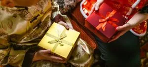 a boy in gold traditional wear holding gift box