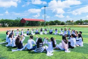 people sitting on green grass with hands up