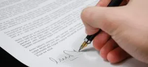 Man writing signature on a paper.