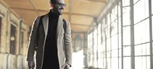 a smiling man walking looking away from the camera