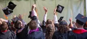 Children throwing graduation caps in the air after overcoming adjustment issues after moving from HK to the USA.