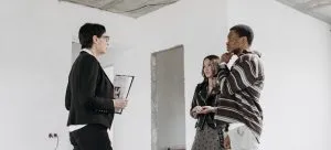 A couple talking to a female real estate agent