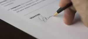 A person signing a contract.