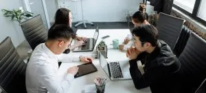 A group of people having a business meeting. Business opportunities are one of the reasons why living in Hong Kong as a young adult is a good option.