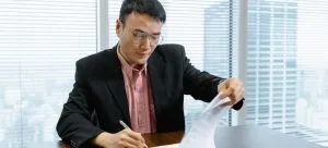 A person signing a contract and finishing legal requirements which is important when moving abroad for a job.